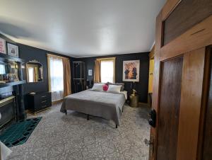 a bedroom with a bed and a fireplace and a television at The Queen Hotel- Downtown Luxury in Sturgeon Bay