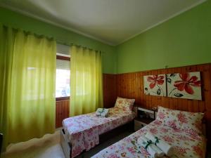 a small bedroom with two beds and a window at Da "Zia Giovanna" in San Giovanni Suèrgiu