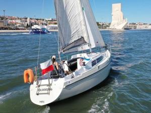 a white sail boat in the water on the water at Vintage sailboat experience in Lisbon