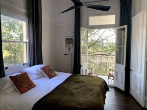 a bedroom with a bed and a large window at Light filled terrace flat in Sydney