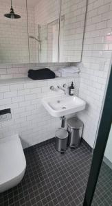 a white bathroom with a sink and a toilet at Light filled terrace flat in Sydney +16 photos