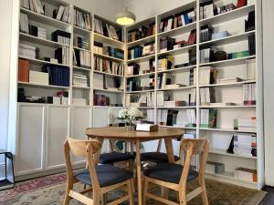 a dining room with a table and chairs and bookshelves at Light filled terrace flat in Sydney