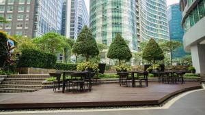 a patio with tables and chairs in a city at Premium 1BR unit at The Avant in Manila