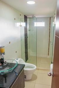 a bathroom with a toilet and a glass shower at Finca Casa Blanca in Armenia