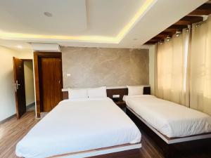 Kama o mga kama sa kuwarto sa Hotel Nirakar
