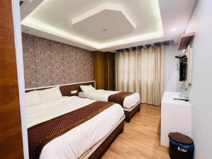 Kama o mga kama sa kuwarto sa Hotel Nirakar