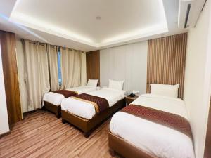 Kama o mga kama sa kuwarto sa Hotel Nirakar