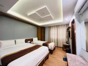 Kama o mga kama sa kuwarto sa Hotel Nirakar