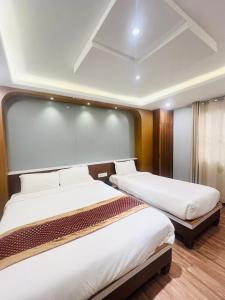 Kama o mga kama sa kuwarto sa Hotel Nirakar