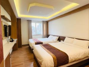 Kama o mga kama sa kuwarto sa Hotel Nirakar