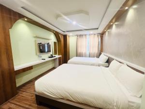 Kama o mga kama sa kuwarto sa Hotel Nirakar
