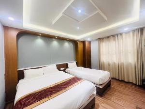 Kama o mga kama sa kuwarto sa Hotel Nirakar