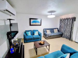un salon avec des canapés bleus et une table dans l'établissement Condominio 231 Loma Bonita, enfrente de la alberca!, à San Carlos