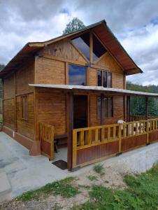 a log cabin with a porch and a fence at Cabaña Buenos aires in Sogamoso