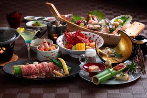 a table with plates of food and bowls of food at Shogetsu Grand Hotel in Jozankei