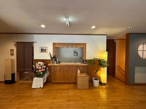 una camera con tavolo da trucco, specchio e fiori di Hakuba Third Place Lodge a Hakuba