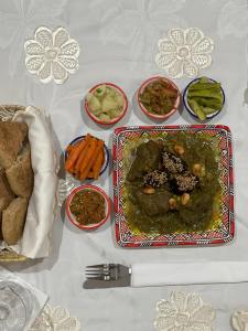 a table with a plate of food and bowls of vegetables at Riad Safia in Rabat