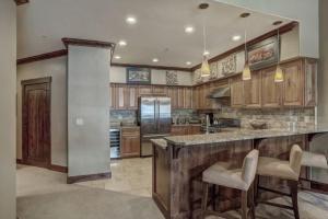 a large kitchen with wooden cabinets and a large island at Crystal Peak Lodge 4 Bedroom Ski In, Ski Out Slopeside Condo At The Base Of Peak 7 in Breckenridge