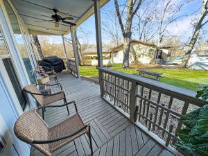 a screened porch with two chairs and a grill at Beaver Lake Getaway in Rogers