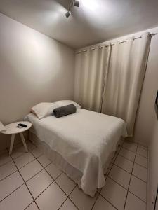 a small bedroom with a bed and a table at Apartamento mobiliado Rio Branco in Rio Branco