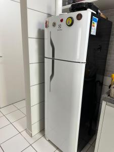a white refrigerator freezer sitting in a kitchen at Apartamento mobiliado Rio Branco in Rio Branco +9 photos