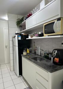 a kitchen with a sink and a microwave at Apartamento mobiliado Rio Branco in Rio Branco
