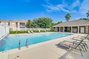 弗利Beautifully Updated Foley Condo with Pool Access的带椅子的游泳池和一栋房子