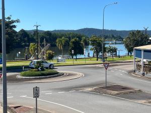 a white car driving down a road with a curve at Innisfail Riverfront Motel in Innisfail +25 photos