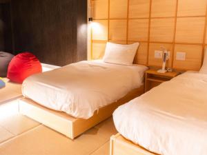 a room with two beds and a lamp in it at Nagasaki Sky Hotel in Nagasaki