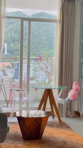 ブンタウにあるCăn Hộ View Biển - Thuy Tien Apartmentのリビングルーム(ガラステーブル、大きな窓付)