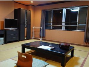 a living room with a coffee table and a tv at Nagasaki Sky Hotel in Nagasaki +102 photos