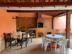 a patio with a table and chairs and a fireplace at Casa Espaçosa para 10 Pessoas com Área de Churrasco e Garagem in Rio das Ostras