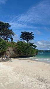 a sandy beach with trees and the ocean at Boracay Condo 1, Ocean Garden Villa Boracay Newcoast in Boracay