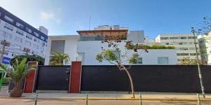 a building with a black fence and a tree at Ana Frank Boutique Hotel in Lima