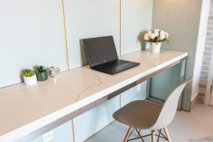 a laptop computer sitting on a counter with a chair at Apartamento luxuoso 178 São João in Sao Paulo