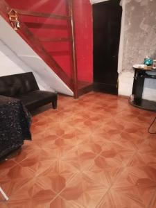 ein Wohnzimmer mit Holzboden und einer Treppe in der Unterkunft SE ARRIENDA 1 HABITACION CASA HUECHURABA, Villa Las Bandurrias in Santiago + 1 Foto