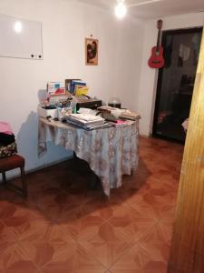 ein Tisch mit Büchern darauf in einem Raum mit einer Gitarre in der Unterkunft SE ARRIENDA 1 HABITACION CASA HUECHURABA, Villa Las Bandurrias in Santiago