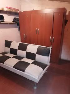 Bett mit schwarzen und weißen Kissen in einem Zimmer in der Unterkunft SE ARRIENDA 1 HABITACION CASA HUECHURABA, Villa Las Bandurrias in Santiago