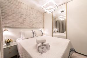 a bedroom with a white bed and a mirror at Apartamento luxuoso 178 São João in Sao Paulo