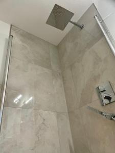a bathroom with a shower with a glass door at Modern Urban Studio Apartment S-Bahn 27QM for 6 persons Mercedes-Benz in Magstadt