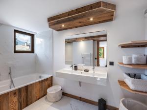 ein Badezimmer mit Waschbecken, Badewanne und Spiegel in der Unterkunft Chalet chaleureux 10 pers, parking Saint-Gervais - FR-1-663-23 in Saint-Gervais-les-Bains