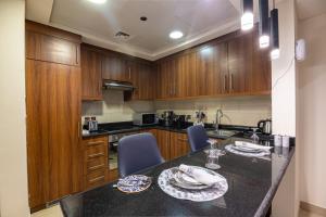 a kitchen with wooden cabinets and a table with chairs at New Apartment City View Rafal Tower Self Check In شقة جديدة مطلة على المدينة برج رافال 2BR in Riyadh