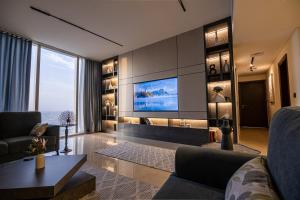 a living room with a flat screen tv on a wall at New Apartment City View Rafal Tower Self Check In شقة جديدة مطلة على المدينة برج رافال 2BR in Riyadh