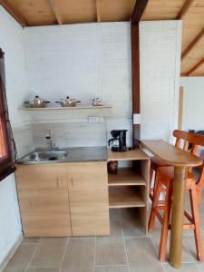 a kitchen with a sink and a wooden table at Ancestral Cabaña in San Vicente