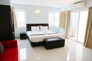 ブリーラムにあるLa VIVA Hotelのベッドと赤いソファのある寝室