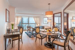 马尼拉Discovery Suites Manila, Philippines的客厅配有桌椅和沙发
