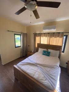 a bedroom with a large bed with a ceiling fan at VillaLunaCaridad in Jarabacoa +22 photos