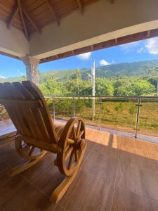a rocking chair on the porch of a house with a view at VillaLunaCaridad in Jarabacoa