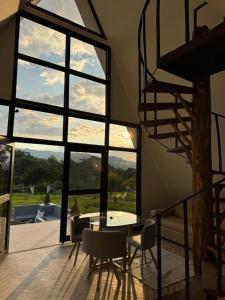 a room with a table and chairs and a large window at Ilusion Cabaña La Florida in Pereira