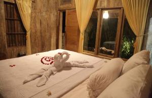a baby doll laying on a bed in a room at Santika Guest House in Ubud